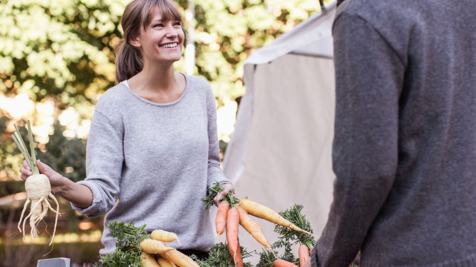 woman holding root vegetables